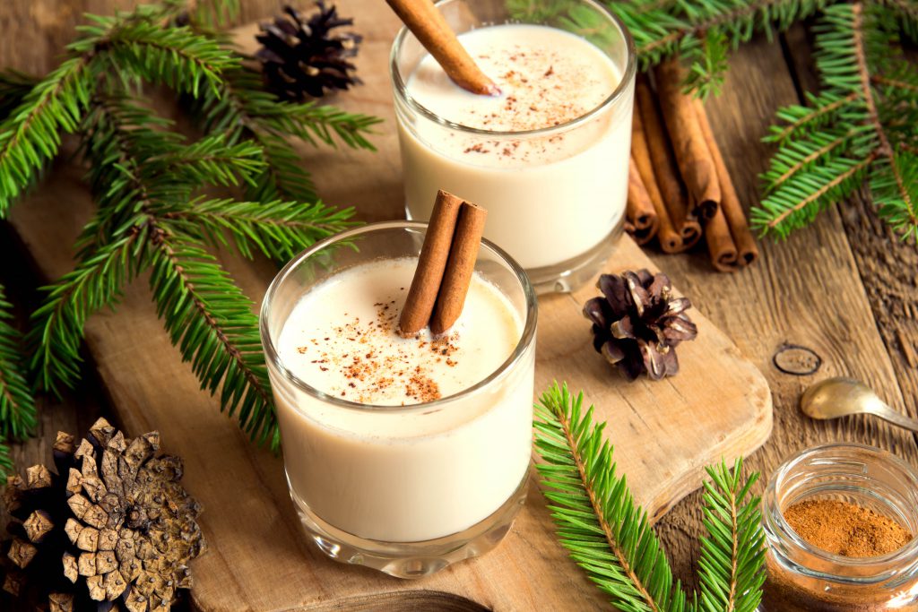 Findyello article on Caribbean Christmas recipes with image of two glasses of eggnog topped with spice.