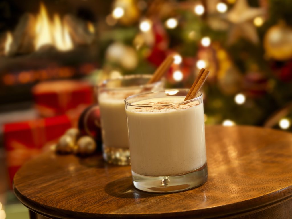 Findyello article on Caribbean Christmas recipes with image of two glasses of eggnog with cinnamon and nutmeg.