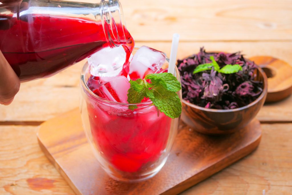 Findyello article on Caribbean Christmas recipes with image showing sorrel drink being poured into a glass.