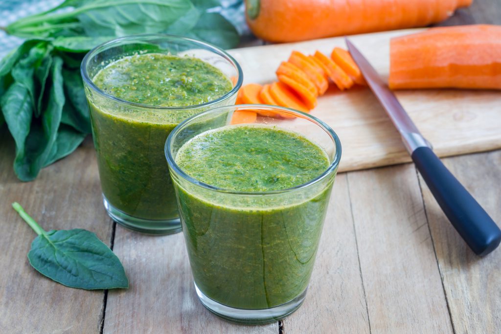 Yello Juice Bar article with carrot and spinach smoothie recipe image shows green spinach carrot smoothie in a glass