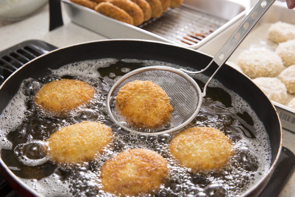 Findyello article on best cooking oil image shows croquette cooking.