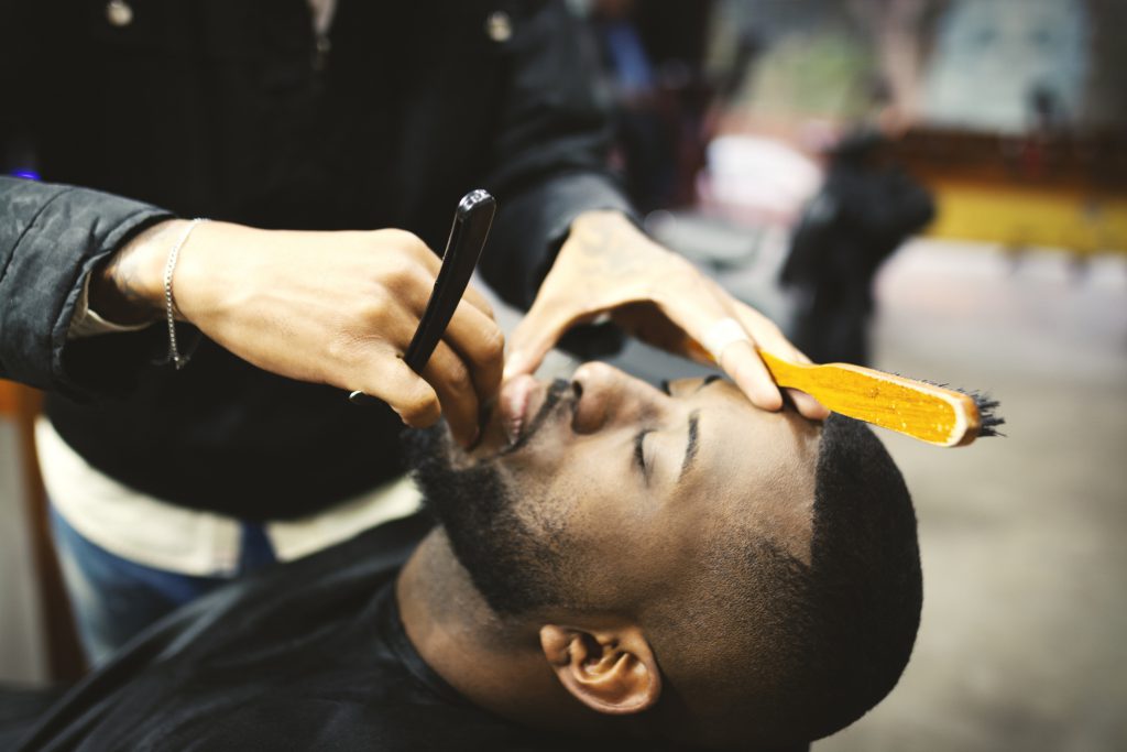 Findyello article Caribbean Man how to treat razor bumps with image showing man in barber shop