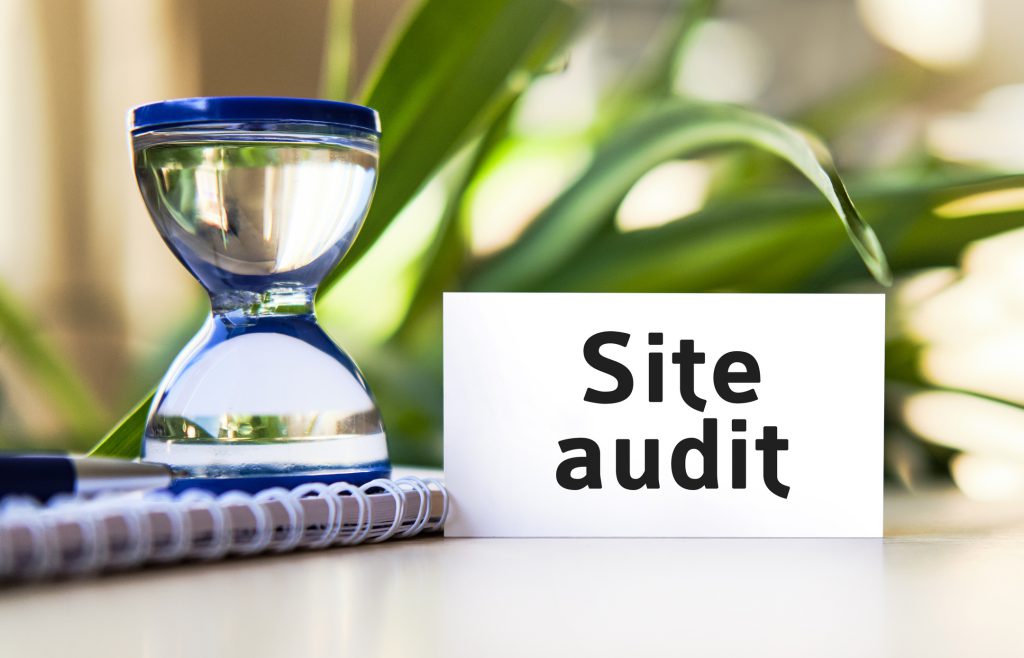 Findyello article on why you need a website audit image shows hourglass and website audit sign