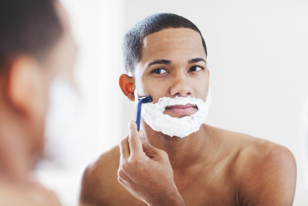 Findyello article Caribbean Man how to treat razor bumps with image showing man shaving