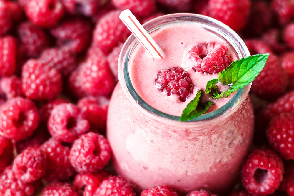 Findyello article on the health benefits of berries with image of raspberries and a raspberry smoothie