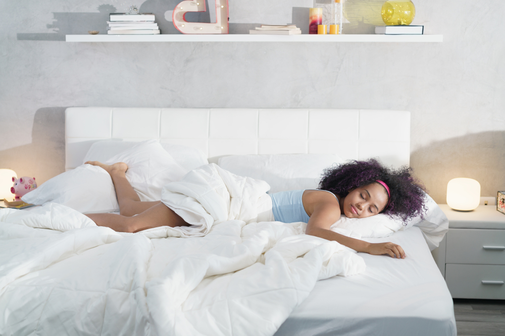 Findyello article with five tips on how to lengthen the lifespan of your mattress with image of girl sleeping in bed.